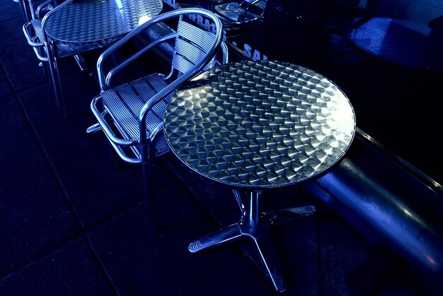 Photo des chaises et une table contre le mur bleu.