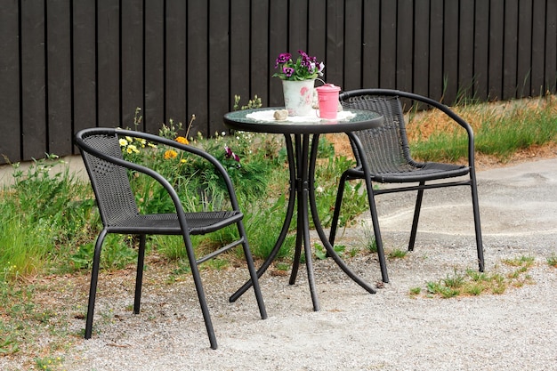 Des chaises et une table avec des fleurs à l'extérieur