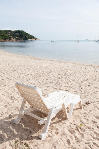 Photo des chaises et une table sur la plage contre le ciel