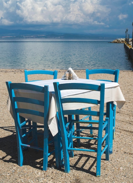 Photo des chaises et une table sur la plage contre le ciel