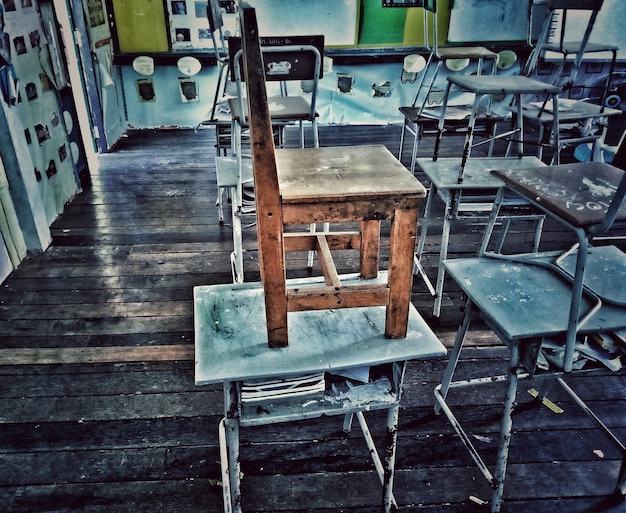 Photo des chaises et une table vides dans une pièce abandonnée.