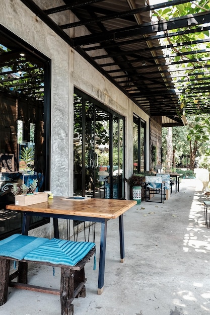 Photo des chaises et une table vides dans un restaurant en face d'un bâtiment.