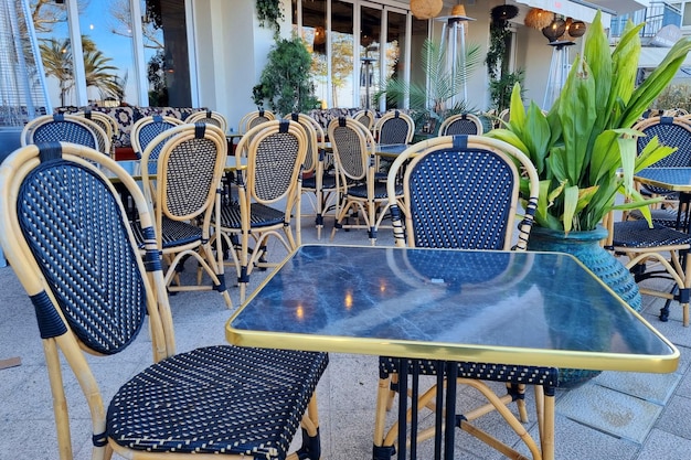 Chaises et tables en bois en osier d'affilée dans un restaurant en plein air vide