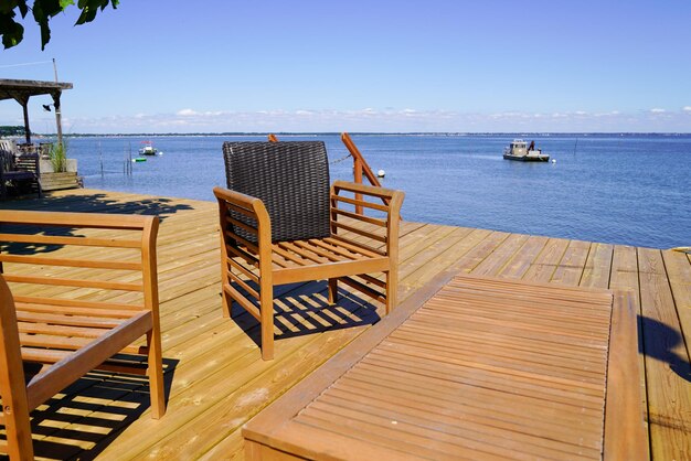 Chaises et tables en bois vides sur la terrasse en bois du restaurant d'huîtres sur la plage du bassin d'Arcachon en France