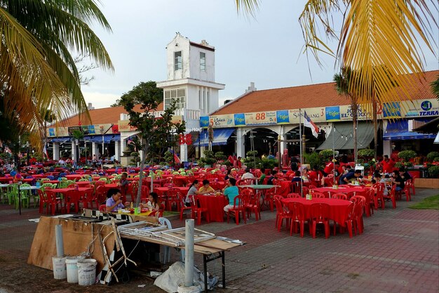 Des chaises et des tables dans un café sur le trottoir en ville contre le ciel