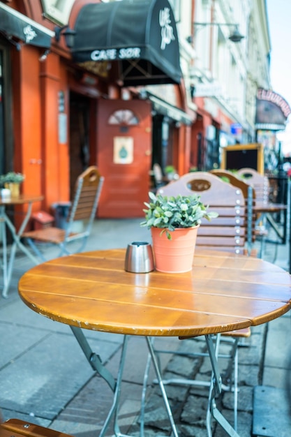 Photo des chaises et des tables dans un café de trottoir en ville