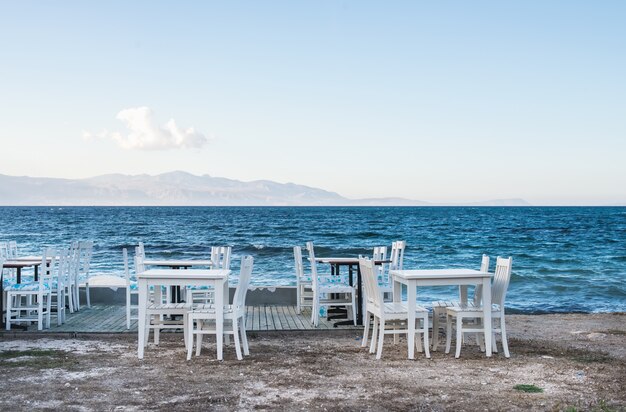 Chaises et tables dans un vieux café près de la mer, village de pêcheurs de Ciftlikkoy, région égéenne, Turquie