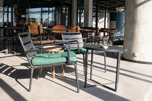 Chaises et tables en métal vides devant le café.