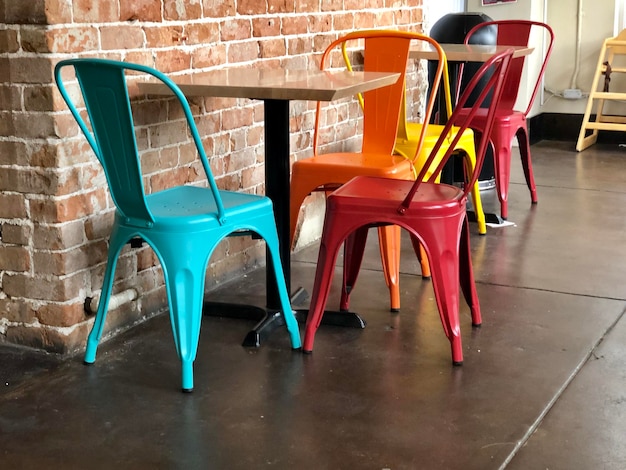 Photo des chaises et des tables vides contre le mur.