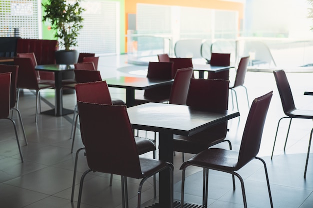 Chaises et tables vides dans une aire de restauration dans un centre commercial.