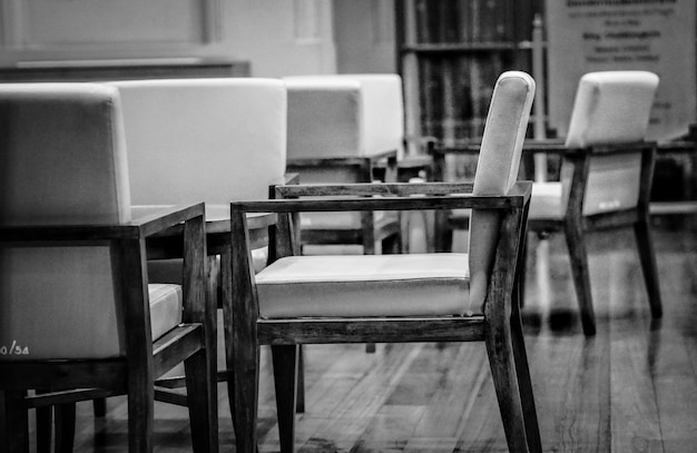 Photo des chaises et des tables vides dans un café contre le bâtiment.