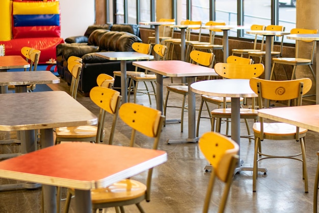 Des chaises et des tables vides dans un café sur le trottoir.
