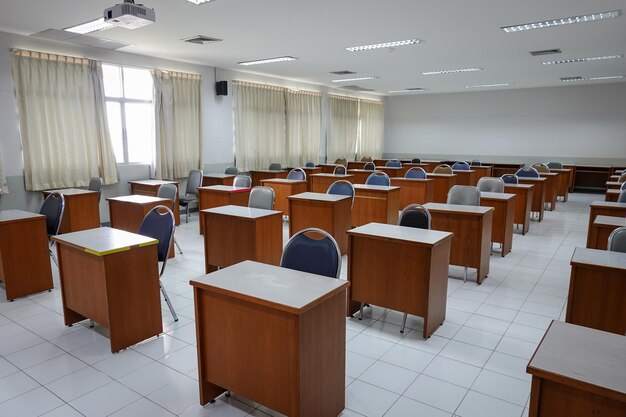 Photo des chaises et des tables vides en rangée.