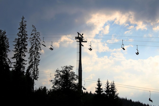 Chaises vides du téléphérique à la station de montagne au coucher du soleil