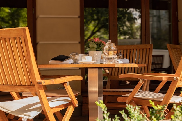 Photo chaises vides et ustensiles de thé sur la table du café