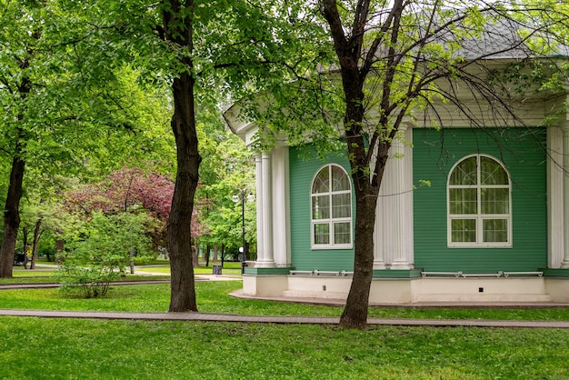 Chalet en bois dans le parc parmi les arbres verts