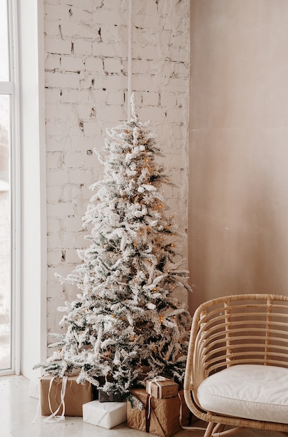Chaleureux et confortable, beau design moderne de la pièce dans des couleurs claires délicates décorées avec un arbre de Noël.