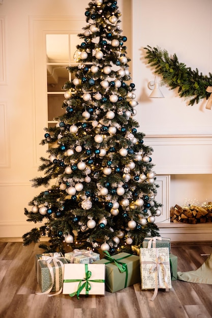 Chaleureux et confortable, belle conception de chambre moderne dans des couleurs claires et douces, décorée d'un arbre de Noël et d'éléments de décoration pour la nouvelle année