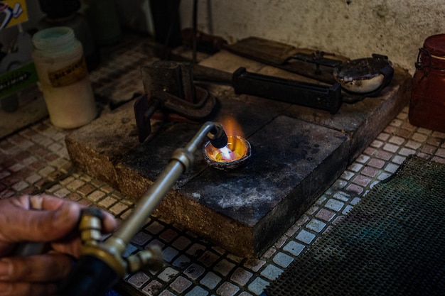 Photo chalumeau faisant fondre une pièce d'argent