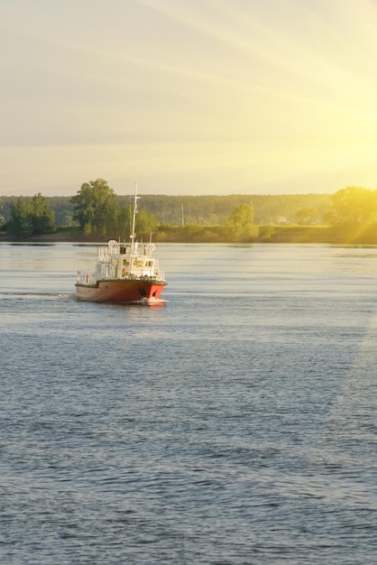 Chalutier de pêche rouge et blanc ou bateau à flot aux tons ensoleillés