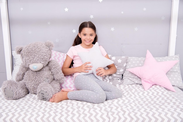 Chambre bien rangée Jolie chambre confortable pour petite fille Fille s'amusant intérieur de la chambre Concept d'enfance Chambre à coucher se détendre et se reposer Enfant en pyjama Bon matin Se sentir bien à la maison