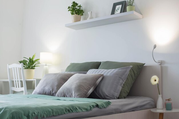 Chambre blanche avec draps gris et verts