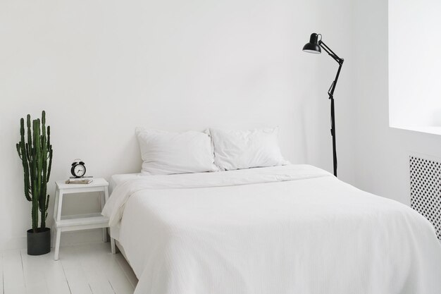 Chambre blanche avec lit et lampe simplicité à la maison