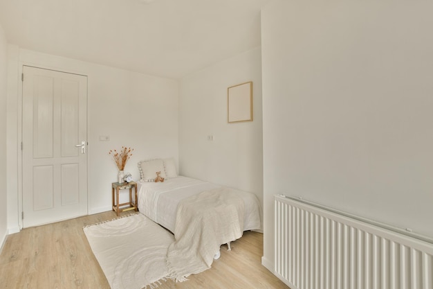 Une chambre blanche avec un lit et un radiateur blanc