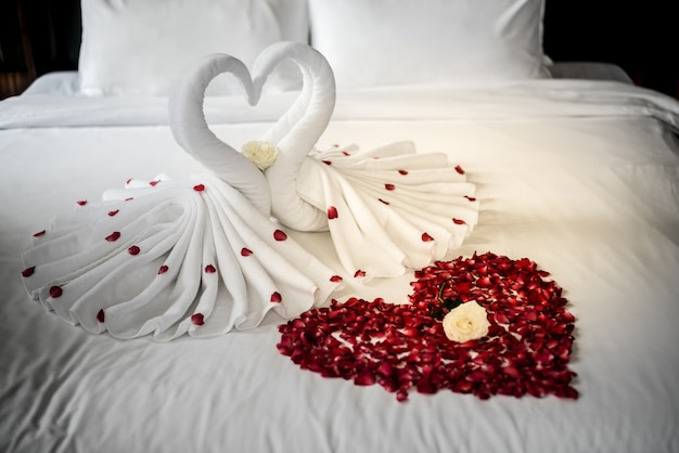 Photo chambre à coucher des mariés, chambre de luxe, lin blanc, cygne blanc, pétale rouge, coeur rouge