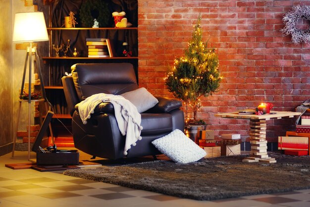 Chambre décorée de Noël avec petit sapin, fauteuil et lampe