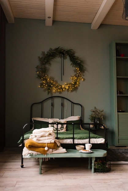 Chambre décorée pour les fêtes de Noël avec une couronne au mur et déco en vert