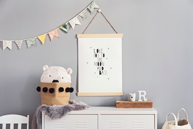 Chambre d'enfant scandinave élégante avec cadre photo en bois, jouets en bois et en peluche, boîtes, blocs et accessoires