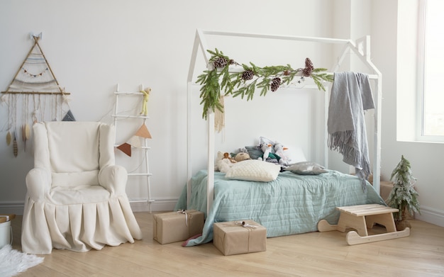 Chambre d'enfants décorée avec fauteuil couvert et lit en forme de maison