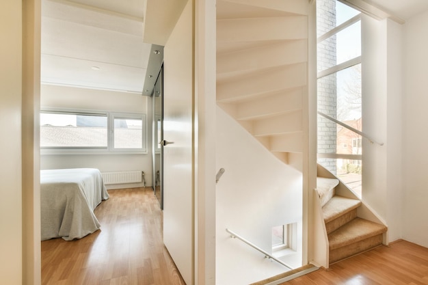 Une chambre avec un escalier et un lit à côté