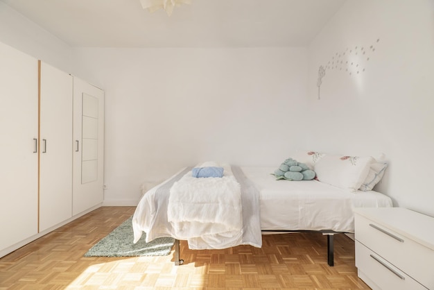 Chambre avec un grand lit double avec une armoire blanche