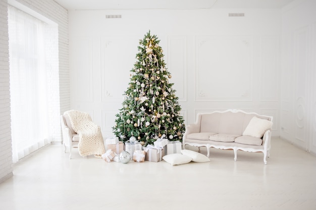 Chambre intérieure décorée de Noël Nouvel An classique Arbre du nouvel an. Arbre de Noël avec des décorations dorées. Design d'intérieur moderne de style classique blanc