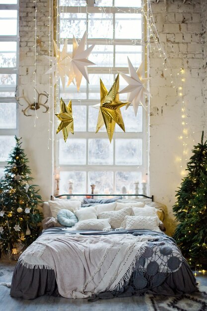 Chambre loft de Noël avec de grandes fenêtres Décorations de Noël Sapins et lumières de Noël Intérieur loft boho avec décor de Noël