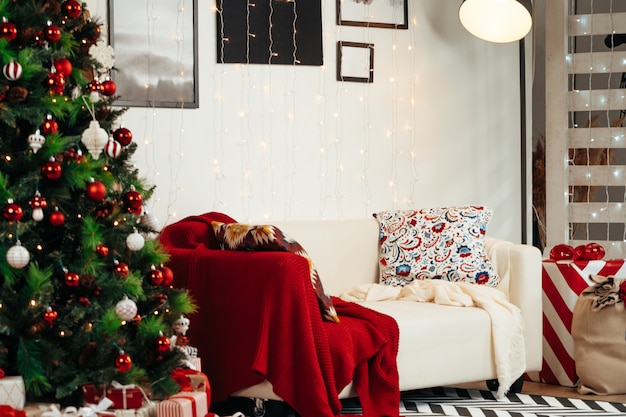 Chambre de Noël joliment décorée avec sapin et canapé blanc