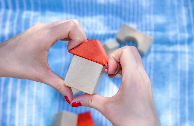 Chambre à partir de cubes en bois dans la main de la femme couverture bleu ongles couleur rouge et un autre éco jouets en zone