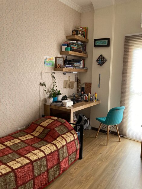 Photo une chambre avec un petit bureau et une chaise bleu vert