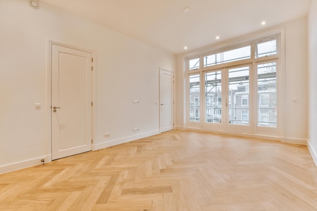 Une chambre spacieuse avec parquet dans les tons blancs et grandes baies vitrées dans une maison cosy