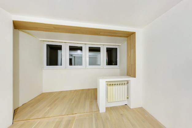 Chambre vide non meublée avec un minimum de réparations préparatoires à l'intérieur avec des murs blancs