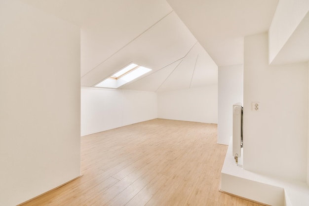 Chambre vide spacieuse avec parquet et petite fenêtre sur le toit dans une maison moderne