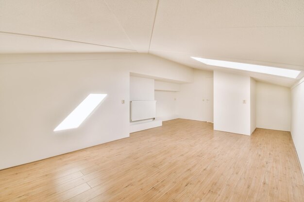 Chambre vide spacieuse avec parquet et petite fenêtre sur le toit dans une maison moderne