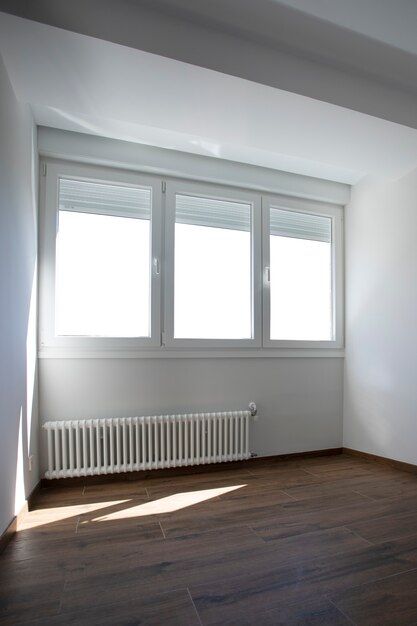 Photo chambre vitrée avec parquet au sol et radiateur à gaz