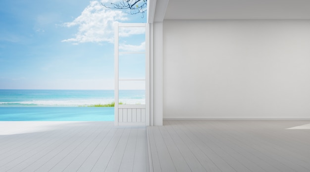 Chambre vue mer de luxe maison de plage d'été avec porte vitrée et terrasse au sol en bois près de la piscine.