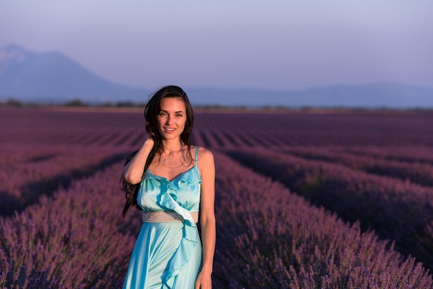 champ de fleurs de lavande portrait de femme en robe cyand s'amuser et se détendre sur le vent