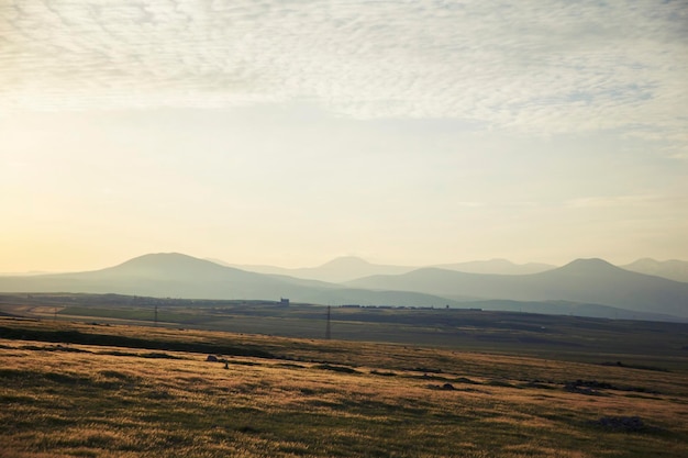 Champ d'herbe et montagnes dans le ciel