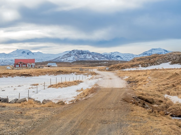 Champ de neige en hiver avec des montagnes en arrière-plan sous un ciel bleu nuageux en Islande