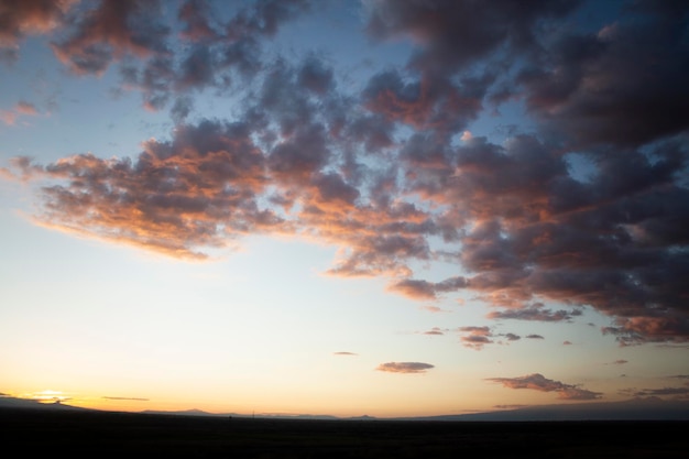 Champ et nuages colorés au coucher du soleil